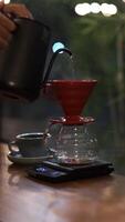 Pouring hot water into a cup on the table outdoor with colorful bokeh background at nigh video