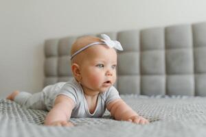 Cute happy 7 month baby girl in diaper lying and playing photo