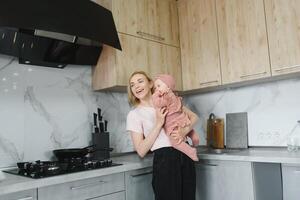 The mother of a woman with a baby cooks the food in a pot on the stove photo
