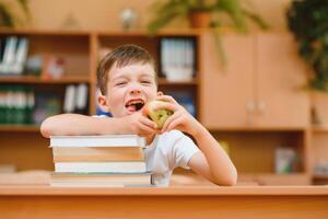 Portrait of cute boy on top of book stack. The concept of learning in primary school. photo