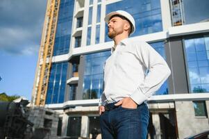 Young handsome man constructor in white hardhat. Close up portrait photo