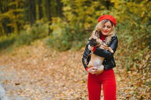 Beautiful and happy woman enjoying in park walking with her adorable French bulldog. photo