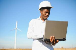 Engineer African man standing with wind turbine photo