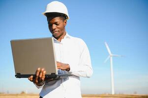 Engineer checks Wind Turbine system with a tablet. Alternative Energy. Wind farm. Clean renewable energy technologies. Wind power plants photo