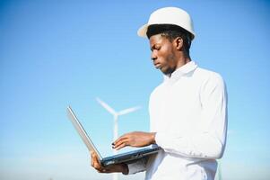 Engineer checks Wind Turbine system with a tablet. Alternative Energy. Wind farm. Clean renewable energy technologies. Wind power plants photo
