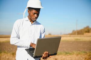 Engineer African man standing with wind turbine photo