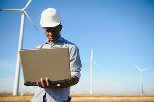 Engineer African man standing with wind turbine photo