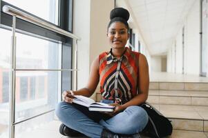 Happy smiling african-american student girl with backpack at university background. Technology, education, leisure concept photo