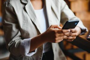 Crop close up of African American woman hold cellphone text message online on gadget. Ethnic biracial female use smartphone browse surf wireless internet on device. Technology, communication concept. photo