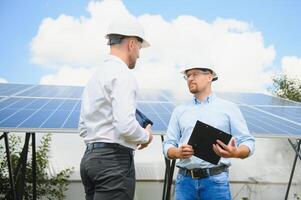 engineer and businessman planing new ecology project. around solar panel photo