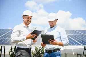 engineer and businessman planing new ecology project. around solar panel photo