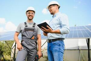 engineer and businessman planing new ecology project. around solar panel photo