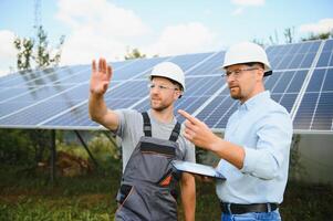 engineer and businessman planing new ecology project. around solar panel photo