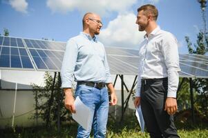 engineer and businessman planing new ecology project. around solar panel photo