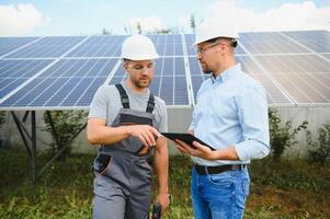engineer and businessman planing new ecology project. around solar panel photo