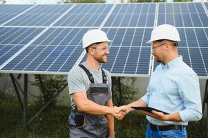 engineer and businessman planing new ecology project. around solar panel photo