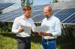 engineer and businessman planing new ecology project. around solar panel photo