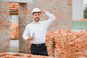 Engineering Consulting People on construction site holding blueprint in his hand. Building inspector. Construction site check drawing and business workflow of new building. photo