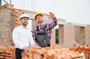 Structural engineer and foreman worker discuss, plan working for the outdoors building construction site photo