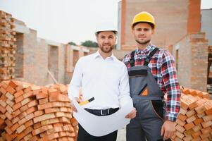 Structural engineer and foreman worker discuss, plan working for the outdoors building construction site photo