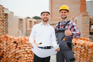 Structural engineer and foreman worker discuss, plan working for the outdoors building construction site photo