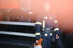 Fireman firefighter in action standing near a firetruck. Emergency safety. Protection, rescue from danger. photo