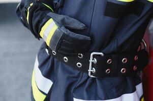Fireman firefighter in action standing near a firetruck. Emergency safety. Protection, rescue from danger. photo