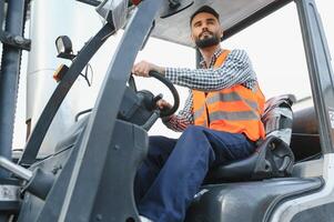 Waving forklift driver in the warehouse of a haulage company while driving forklift photo