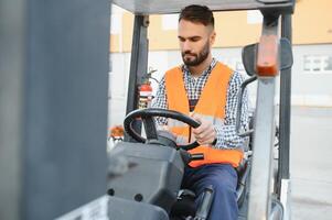 Waving forklift driver in the warehouse of a haulage company while driving forklift photo
