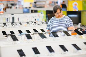 Indian woman choosing a new mobile phone in a shop photo
