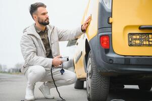 Man holding power connector for electric car photo