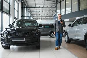 Man adult customer male buyer client wears classic suit white shirt chooses auto wants to buy new automobile touch check car in showroom photo