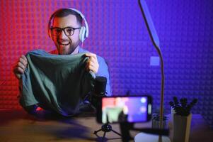 vlogger using smartphone to film podcast in studio. blogger with mobile phone, microphone and headphones filming for social media broadcasting career. photo