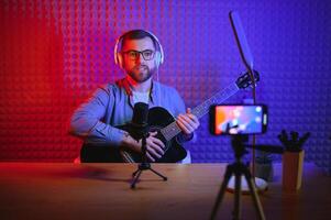 vlogger using smartphone to film podcast in studio. blogger with mobile phone, microphone and headphones filming for social media broadcasting career. photo
