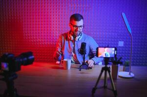 A blogger records content in his studio. The host of the blog is a young man who is very enthusiastic about telling his subscribers a story. photo