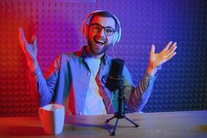 A blogger records content in his studio. The host of the blog is a young man who is very enthusiastic about telling his subscribers a story. photo