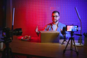 A blogger records content in his studio. The host of the blog is a young man who is very enthusiastic about telling his subscribers a story. photo