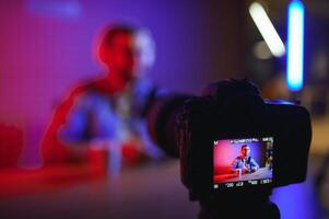 A blogger records content in his studio. The backstage photo was taken from behind one of the participants in the shooting, at the beginning of the shooting when the blogger is preparing.