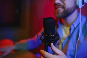 A blogger records content in his studio. The host of the blog is a young man who is very enthusiastic about telling his subscribers a story. photo