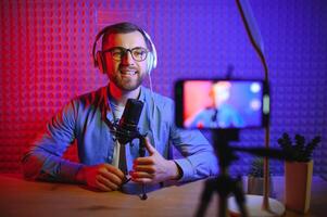 A blogger records content in his studio. The host of the blog is a young man who is very enthusiastic about telling his subscribers a story. photo