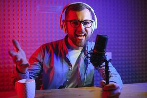 A blogger records content in his studio. The host of the blog is a young man who is very enthusiastic about telling his subscribers a story. photo