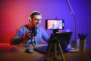 A blogger records content in his studio. The host of the blog is a young man who is very enthusiastic about telling his subscribers a story. photo