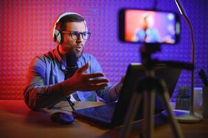 A blogger records content in his studio. The host of the blog is a young man who is very enthusiastic about telling his subscribers a story. photo