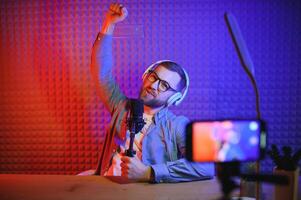 A blogger records content in his studio. The backstage photo was taken from behind one of the participants in the shooting, at the beginning of the shooting when the blogger is preparing.