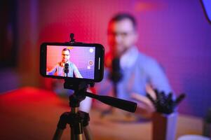 A blogger records content in his studio. The host of the blog is a young man who is very enthusiastic about telling his subscribers a story. photo
