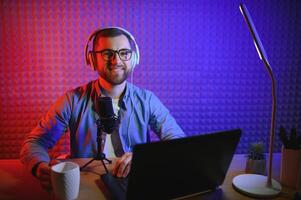 vlogger using smartphone to film podcast in studio. blogger with mobile phone, microphone and headphones filming for social media broadcasting career. photo