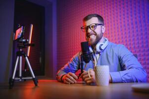 A blogger records content in his studio. The host of the blog is a young man who is very enthusiastic about telling his subscribers a story. photo