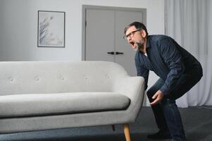 Senior man is suffering from pain in lower back at home photo