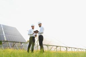 engineer and businessman planing new ecology project. around solar panel. photo