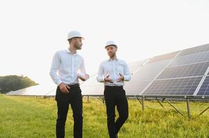 engineer and businessman planing new ecology project. around solar panel. photo